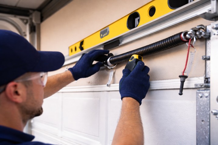 Technician performing overhead garage door repair Tarzana on residential garage door