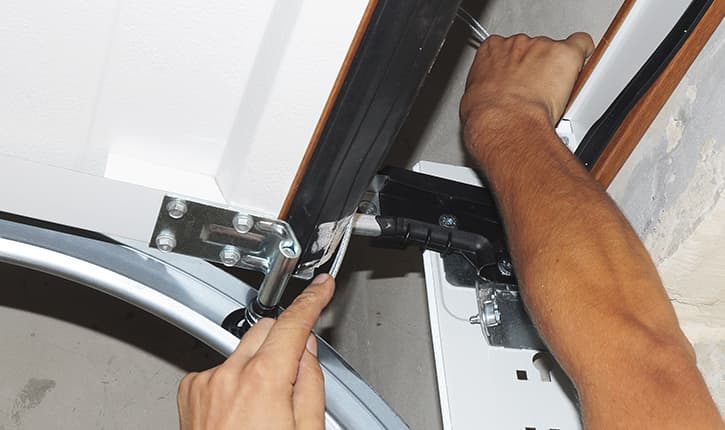 Technician performing garage door repair Reseda on residential garage door system