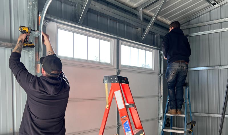 Technician installing modern garage doors Reseda on residential home with contemporary design