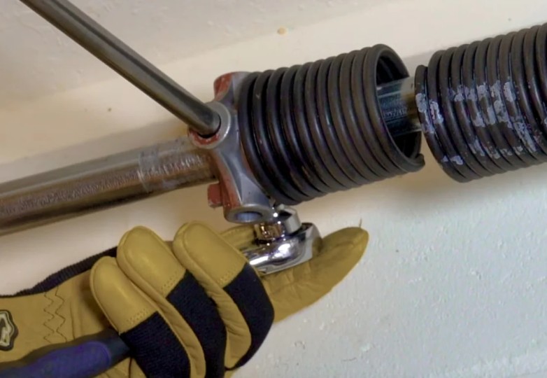 Technician performing broken garage door spring repair Tarzana on residential garage door system